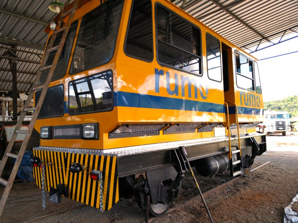 Vagão de trem amarelo da Rumo em operação no setor ferroviário